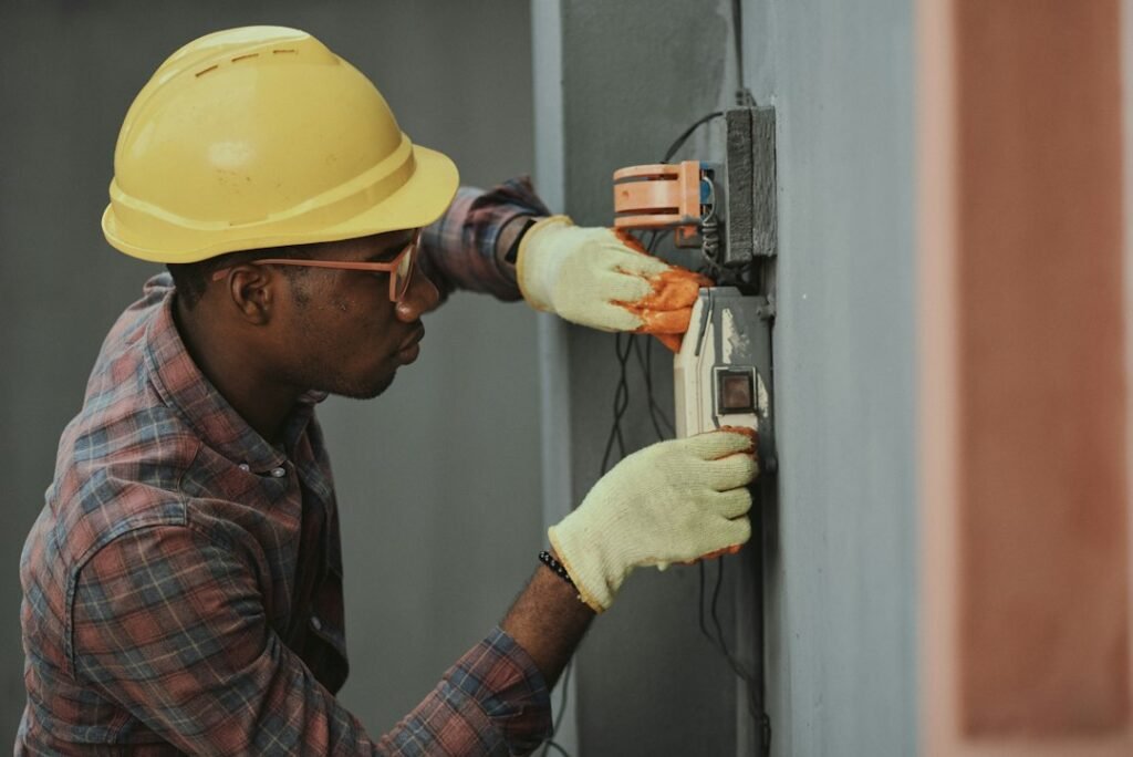 Electrical worker at a construction site wearing protective equipment.