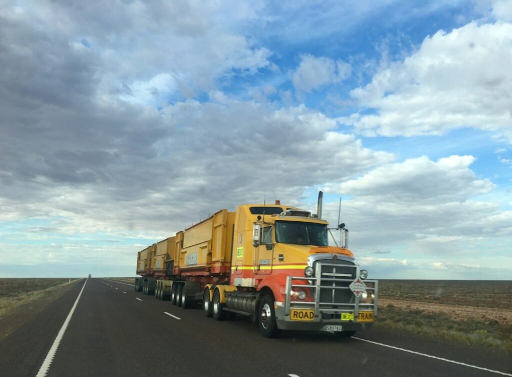 Truck travelling along a road in a remote landscape.